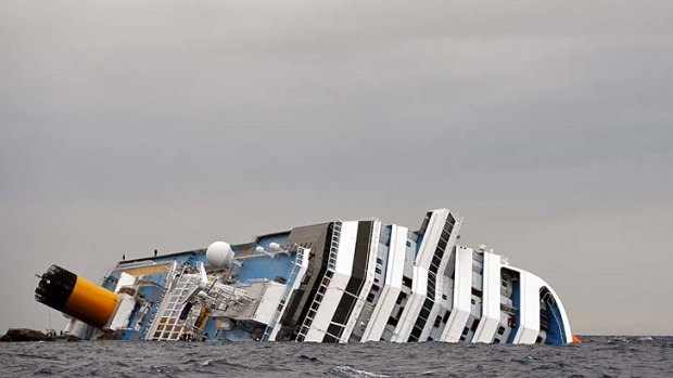 A sea gull flies over the partially submerged Costa Concordia ship