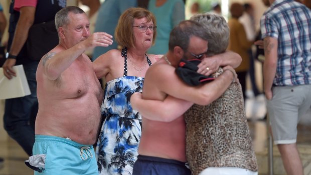 Tourists console each other following a shooting attack in the Tunisia resort town of Sousse.