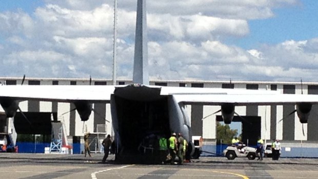 Luggage is unloaded from the plane carrying evacuated Bundaberg Base Hospital patients at Brisbane Airport.