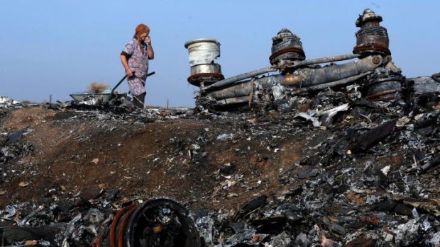 A woman walking among the wreckage of the MH17 crash site. 