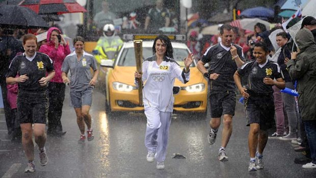 Drenched &#8230; Gemma Flaxman takes the Olympic flame into Southend-on-Sea.