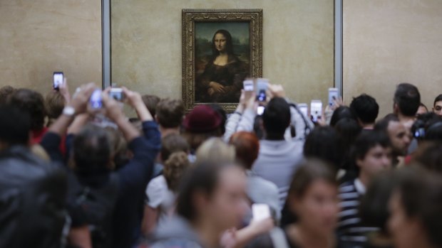 Visitors crowded in front of Leonardo da Vinci's painting 'Mona Lisa' at the Louvre. 