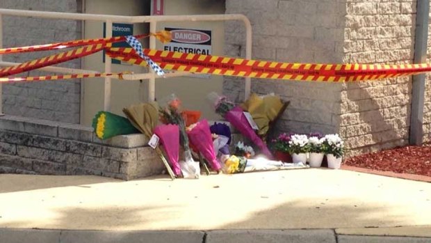 Flowers have been placed at the site of the blast that killed two people and left two others in a critical condition