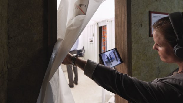 A participant is led through the Situation Rooms by an iPad.