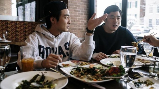 Roy Kim gets lunch with friends, including Brian Chung, right, at a Thai restaurant close to the Georgetown campus. Kim said that in South Korea, he wouldn't be able to dine in public like he does in the US.