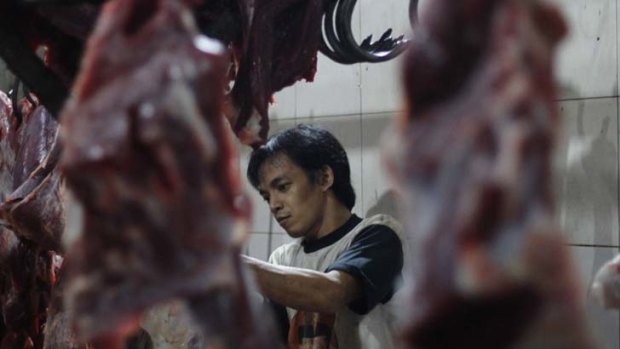About to close ... a worker butchers beef in the Gondrong abattoir where Australian cattle were filmed being mistreated.