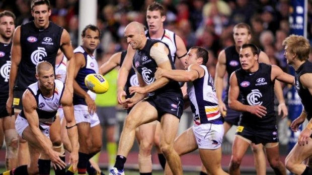 A multitude of players gather around the ball during a game between Carlton and Adelaide in 2012.