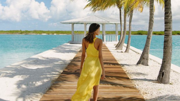 Young woman strolling on beach pier, Providenciales, Turks and Caicos Islands, Caribbean.
