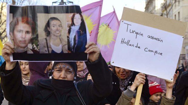 A woman of Kurdish origin holds a poster showing the photos of the three Kurdish women activists killed in Paris. A co-founder of the Kurdistan Workers' Party and two other militants were found shot dead, a day after Turkey and the jailed leader of the banned group were reported to have agreed on a peace plan to end a three-decade-old insurgency.