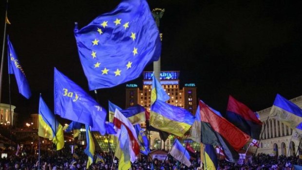 Demonstrators wave EU and Ukrainian flags during a rally in central Kiev.