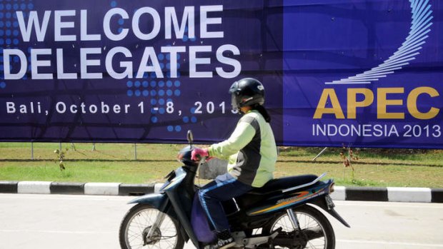 A motorist passes a giant banner for APEC in Nusa Dua, Bali.