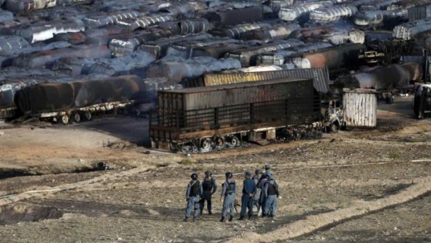 Afghan policemen at the site of burning fuel trucks after a July 5 attack by the Taliban near Kabul. With the situation in Afghanistan far from stable, a lot is riding on the election outcome.