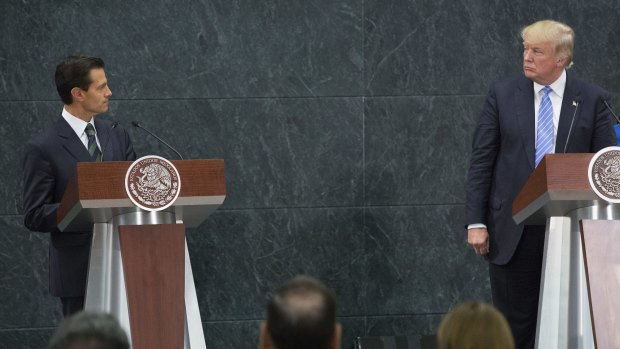 Mexican President Enrique Pena Nieto, left, looks at Donald Trump during a press conference in Mexico City.