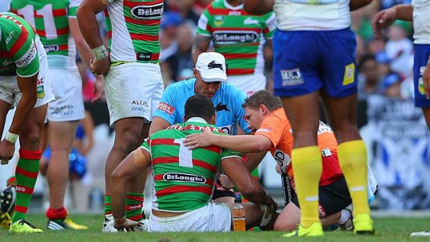 Unhurt: South Sydney star Greg Inglis receives attention after the tackle.