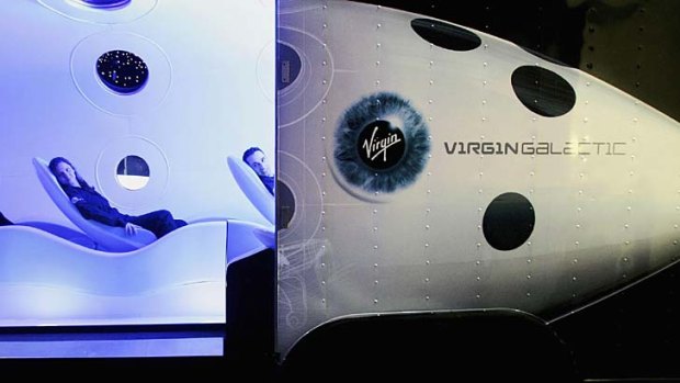 Space is a "risky business" ... Virgin employees sit in the cabin of a prototype Virgin Galactic SpaceShipTwo spacecraft.