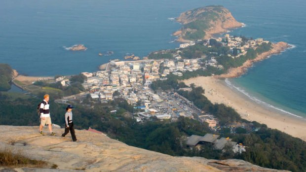 Hikers near the Dragon's Back trail overlooking the village of Shek O, Hong Kong.