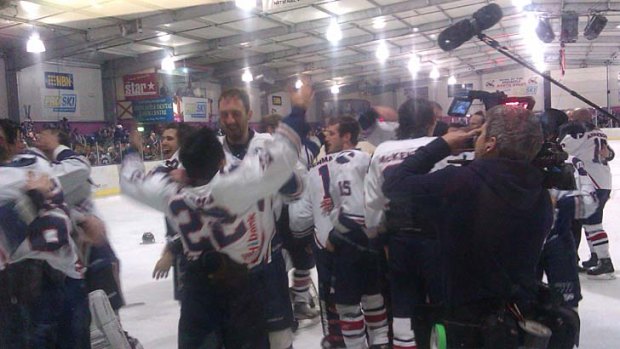 Ice players celebrate after winning the Goodall Cup, watched closely, as always, from the documentary crew producing a "Road to Threepeat" series.