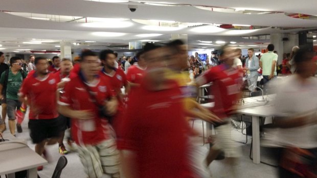 Chilean fans run through the media centre at the Maracana.