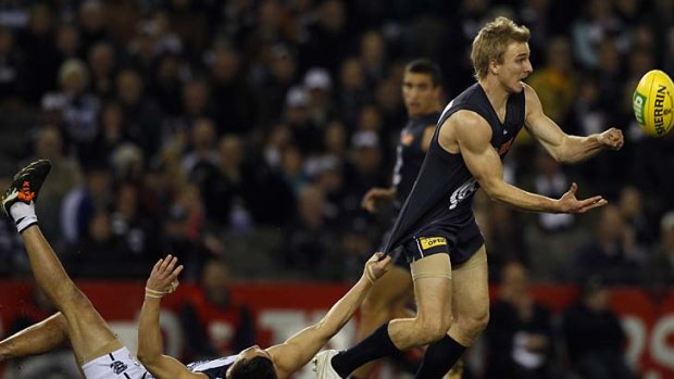 Under pressure: Carlton's Dennis Armfield gets a handball away at Etihad Stadium despite Mathew Stokes's efforts, but the Cats have maintained their grip on victory over the Blues at the venue for nearly nine years.