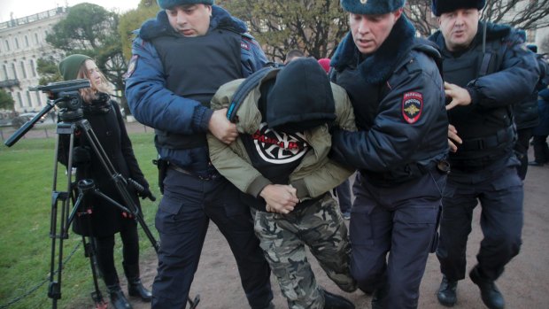 Police officers detain a man during a protest in St.Petersburg, Russia, on Sunday, in which scores were arrested.