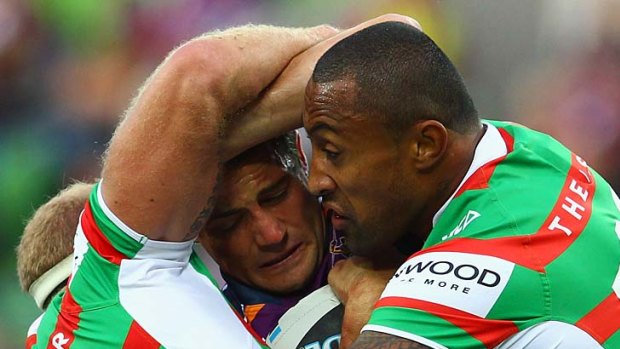 Rabbitoh punch: Cooper Cronk is swamped by South Sydney's Michael Crocker (left) and Roy Asotasi yesterday.