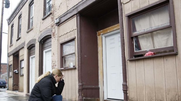 Christine Santos, a family friend of LaShanda Armstrong, takes a moment in front of the family's home in Newburgh.