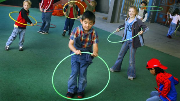 Children enjoy playing with hula hoops in the playground of the Melbourne Museum.