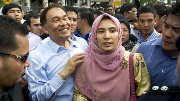 Not guilty ... Malaysian opposition leader Anwar Ibrahim (centre left) celeberates the court decision with his daugther Nurul Izzah (centre right) outside the court in Kuala Lumpur.