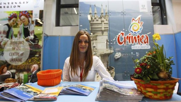 A volunteer waits for visitors at the booth representing Ukraine during the opening day at the International Tourism fair (ITB) in Berlin.