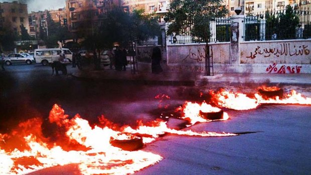 A road blocked with burning tyres in Al-Midan district of the Syrian capital Damascus.