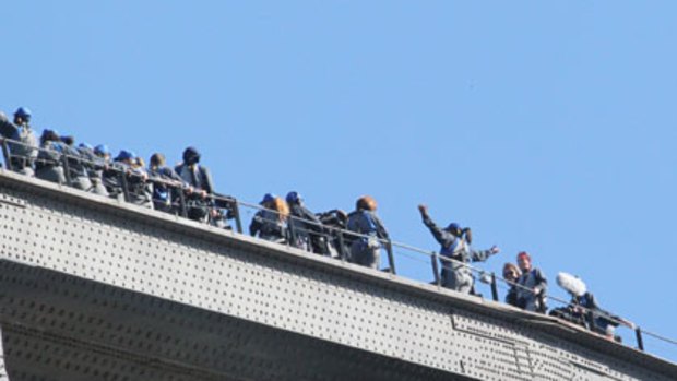 Oprah Winfrey raises her arms for a photo at the top of the Sydney Harbour Bridge.