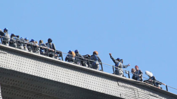 Oprah Winfrey raises her arms for a photo at the top of the Sydney Harbour Bridge.