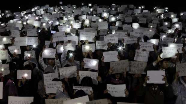 Danwon High School students hold papers with messages such as "miss you", "love you" and "don't lose your hope" for their friends who are missing.