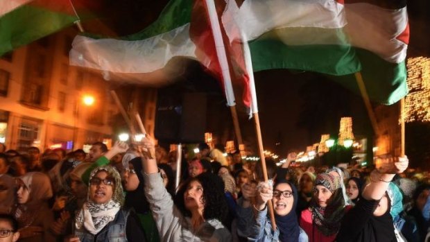 Moroccans hold placards and flags as they shout slogans during a demonstration in supporting Palestine.