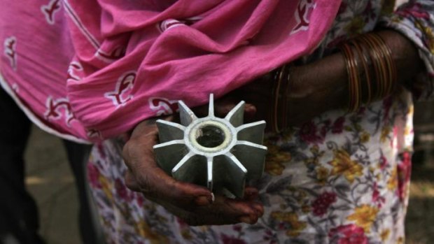 Evidence: A villager holds a metal propeller of a mortar, which locals say was fired from the Indian side of the Pakistani border town of Dhamala Hakimwala.