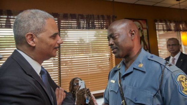 Attorney General Eric Holder speaks with Captain Ron Johnson of the Missouri State Highway Patrol at Drake's Place Restaurant in Ferguson.