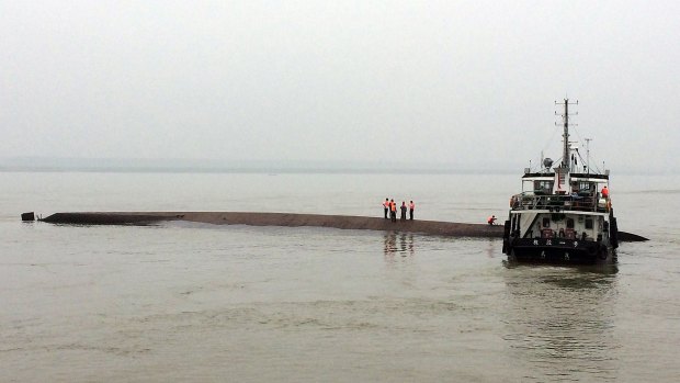 A Chinese rescue boat  alongside a capsized passenger ship carrying more than 450 people which sank in the Yangtze River on Monday night.