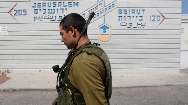 An Israeli soldier walks past a sign pointing out distances to Jerusalem and Beirut at the Rosh Hanikra border crossing with Lebanon.