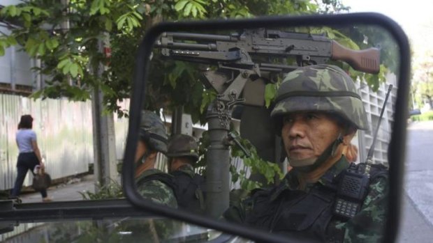 Dangerous days: Thai soldiers guard police HQ in Bangkok on Tuesday, after martial law was announced.