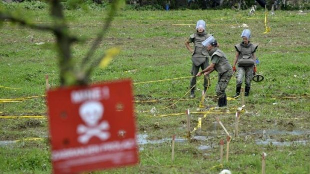 Bosnian soldiers repair mine warning signs in fields near the banks of the river Bosnia, which flooded near the town of Visoko, 30 km north of Sarajevo.