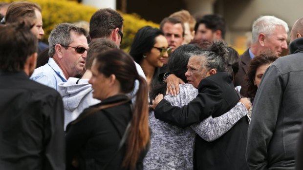 Farewelled: Carly McBride's mother Lorraine Williams (right) hugs a mourner following the funeral of her slain daughter.