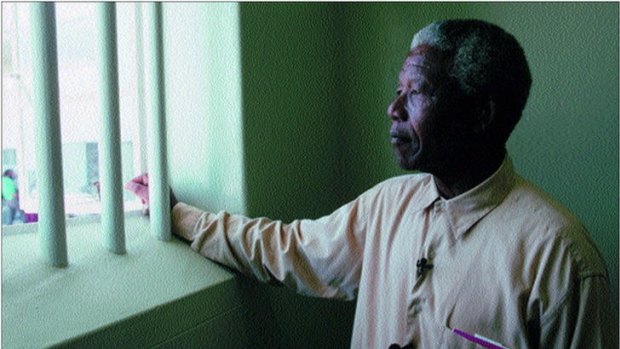 Nelson Mandela revisiting the jail cell he was held in at Robben Island jail.