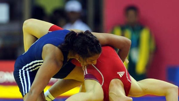 India's Geeta (L) defeats Australia's Emily Bensted in the women's 55 kg wrestling final.