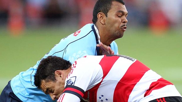 Kurtley Beale of the Waratahs is tackled by Dan Carter of the Crusaders.
