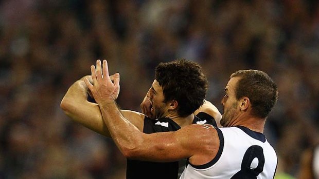 Josh Hunt of the Cats gives away a 50-metre penalty against Alex Fasolo of the Magpies.