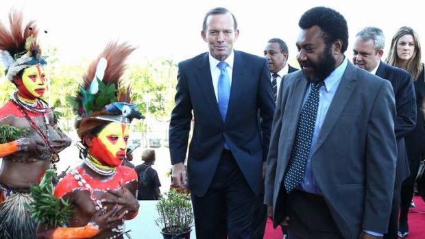 Prime Minister Tony Abbott is greeted by Singsing dancers on his arrival at Parliament House in Port Moresby.