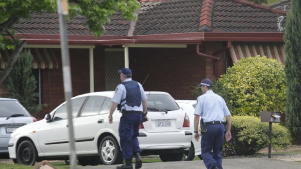 Police walk down a neighbour's driveway in Holmes Street after the shooting this morning.