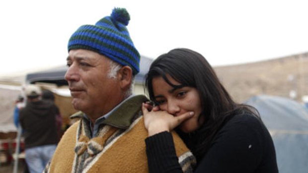 Relatives of a trapped miner, Carlos and Tabita Galleguillos, wait for news from the mine.