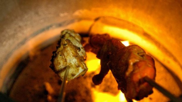 Cooking in a tandoor oven.