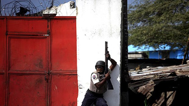A policeman takes position during riots with looters in downtown Port-au-Prince.